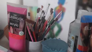 Paint tubes, brushes, and colorful painting.