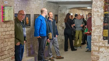 People gathering in a brick-walled art gallery.