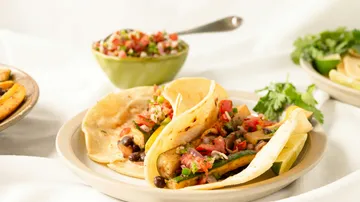 Tacos mit Gemüse und Salsa auf Teller.