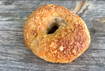 Goldbrauner Bagel auf Holzoberfläche.