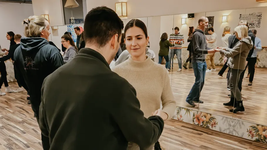 People dancing in a mirrored dance studio.