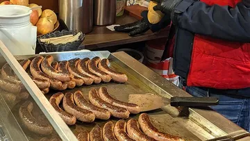 Grilled sausages on a flat grill indoors.