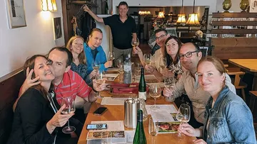 Gruppe genießt Wein an einem Restauranttisch.