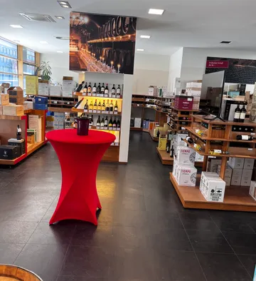 Wine shop with red table and shelves.