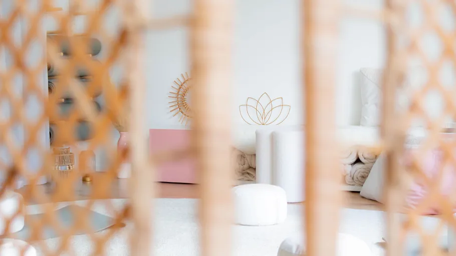 Helles Yogastudio mit Korbtrennwand.