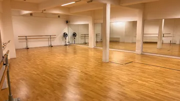 Empty dance studio with wooden floors.