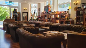 Cozy lounge with brown leather sofas.