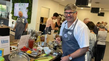 Man cooking in a busy kitchen setting.