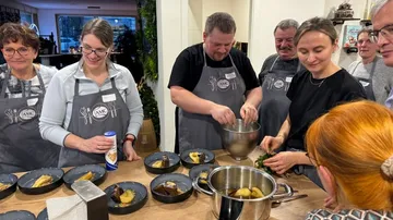 Group cooking together in a kitchen.