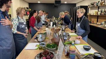 People attending a cooking class in a kitchen.