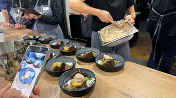 Person serves dessert in a kitchen setting.