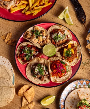 Plate with assorted tacos and lime.