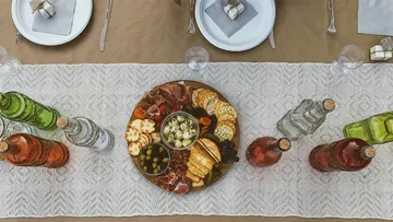 Charcuterieteller auf Tisch mit Getränken.
