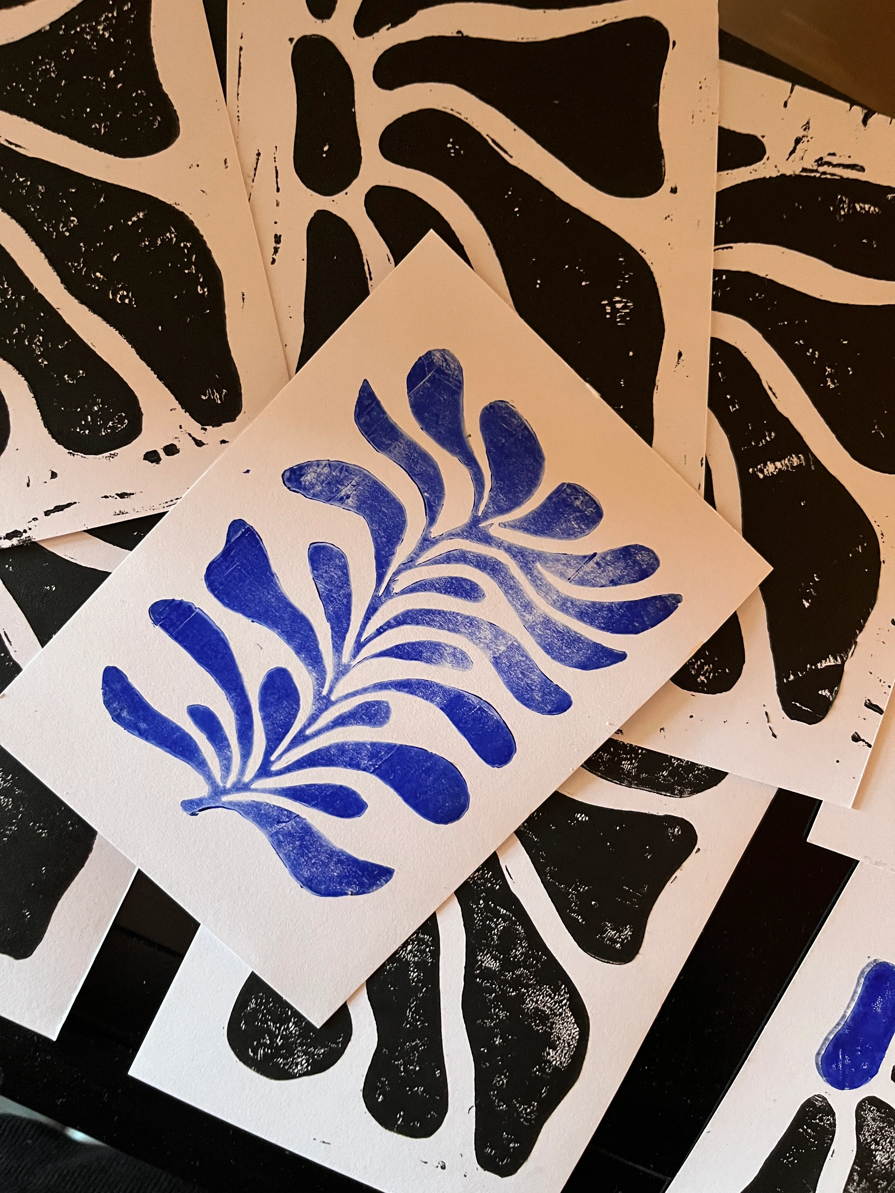 Blue leaf print overlapping black prints.