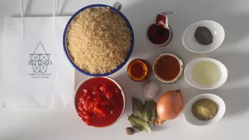 Ingredients for rice dish on white table.