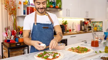 Mann macht Pizza in der Küche.