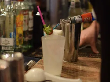 A drink is decorated with syrup in a bar.