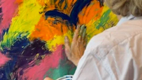 Person malt farbenfrohe abstrakte Kunst mit Fingern.