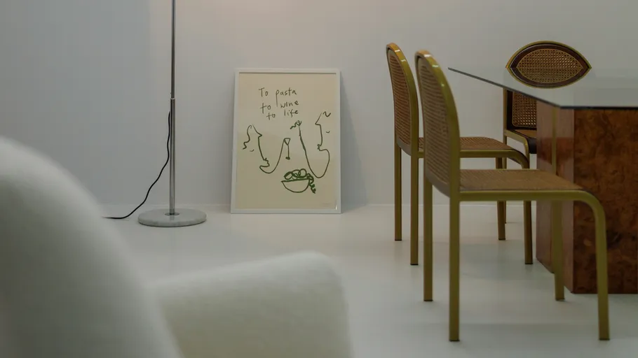 Dining room with framed art and chairs.