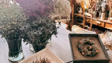 Trockenblumenarrangements auf Holztisch.