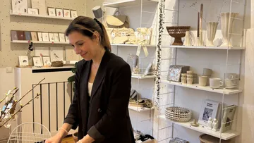 Frau ordnet Schmucktablett in gemütlichem Laden.
