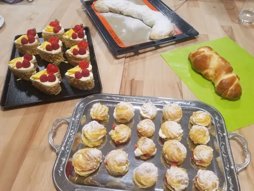 Colourful baked goods are being prepared on a wooden work station.