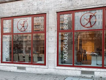 Kochschule in Berlin mit großen Fenstern und Stühlen innen.