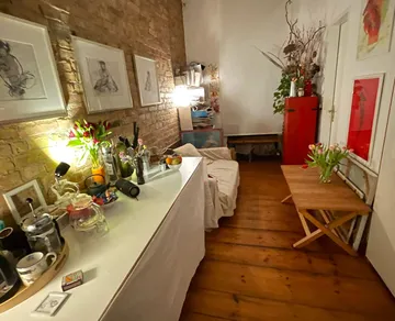 Gemütliches Wohnzimmer mit Ziegelwand, Kunst, Blumen.