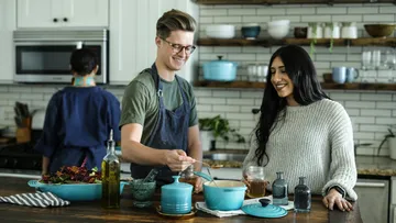 Two people cooking in a modern kitchen.