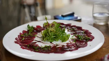 Rote Bete Carpaccio mit Rucola auf Teller.
