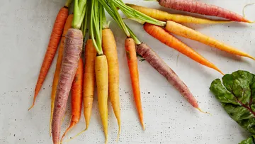 Colorful carrots scattered on a table.