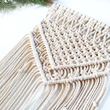 A decorative macrame pendant with fringed ends