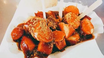 Currywurst served on a paper tray.