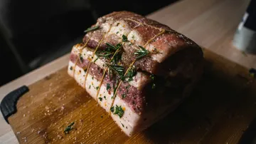Seasoned pork roast on wooden cutting board.