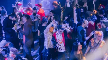Verkleidete Menschen tanzen auf einer Halloween-Party.