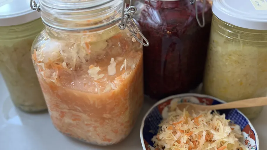 Jars of sauerkraut and fermented vegetables displayed.