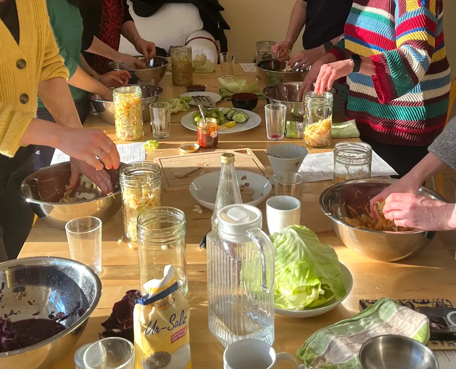Menschen bereiten Essen an einem Tisch vor.