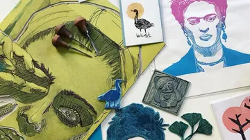 Artistic prints and tools on display table.
