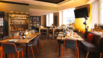 Gemütliches Restaurant mit Holztischen und warmer Beleuchtung.