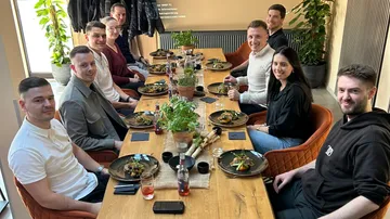 Group dining together at a wooden table.