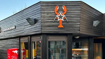 Building with mounted lobster logo and window.