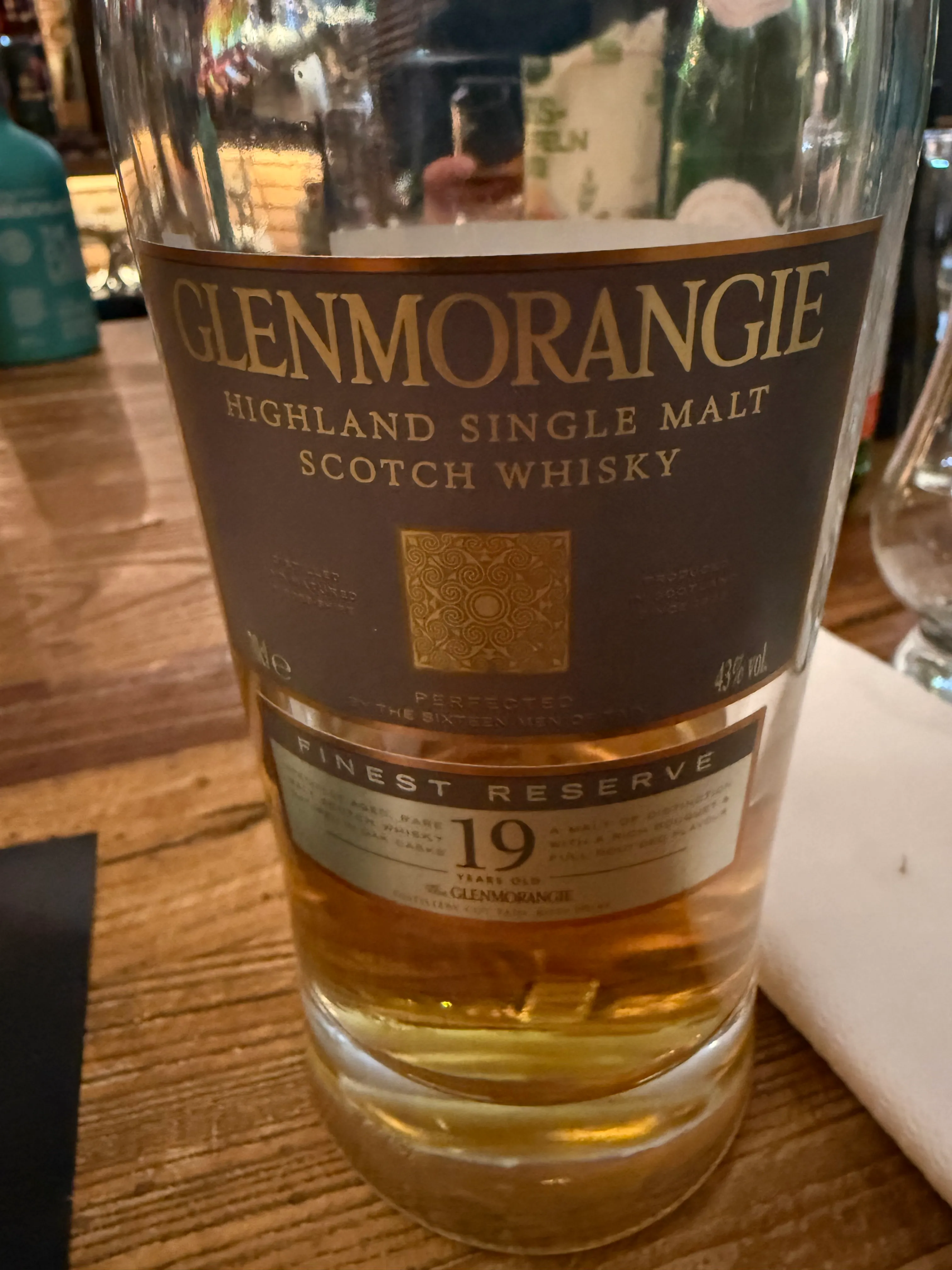 Glenmorangie whisky bottle on wooden table.