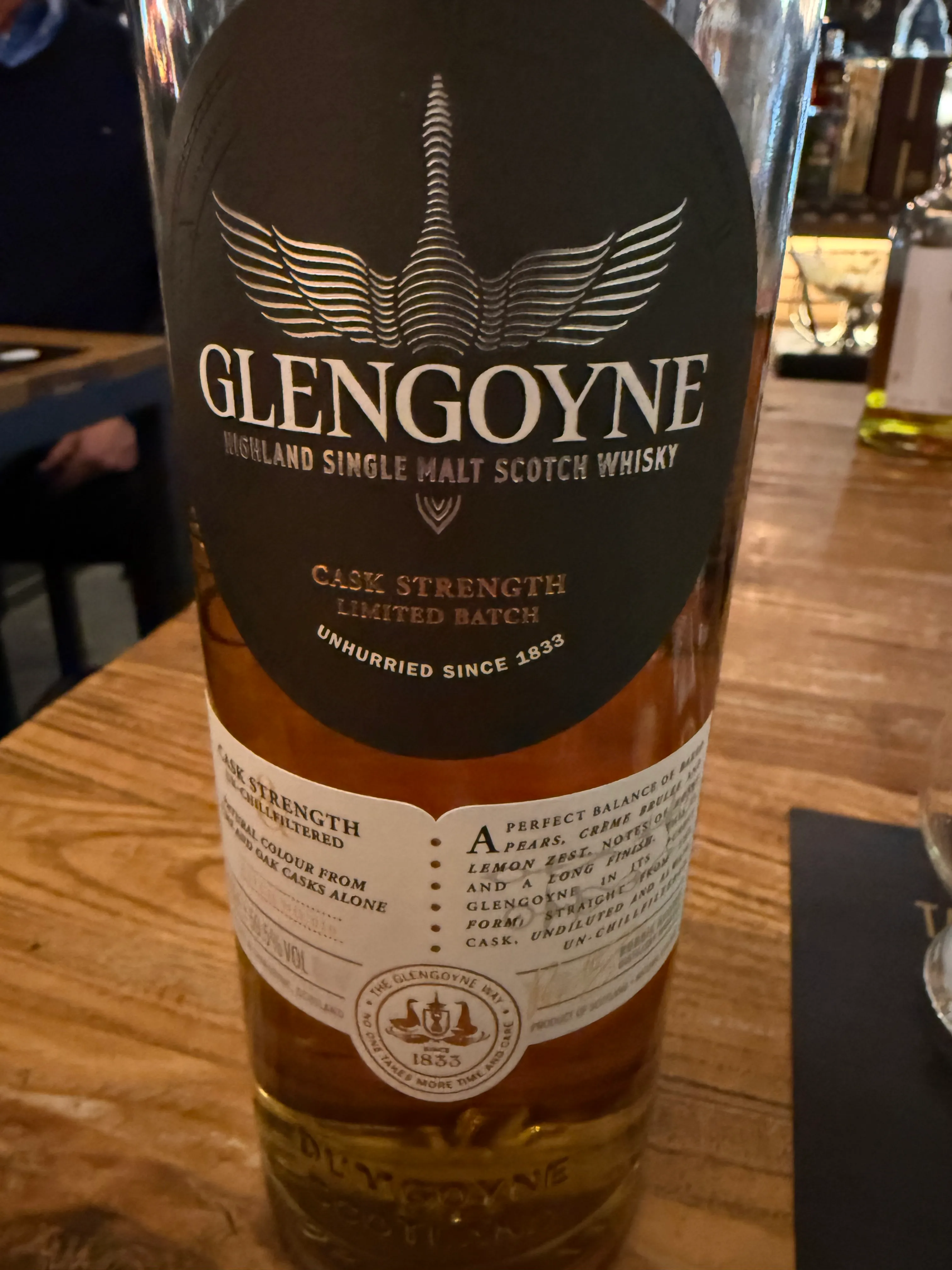 Whisky bottle on a wooden table, bar background.