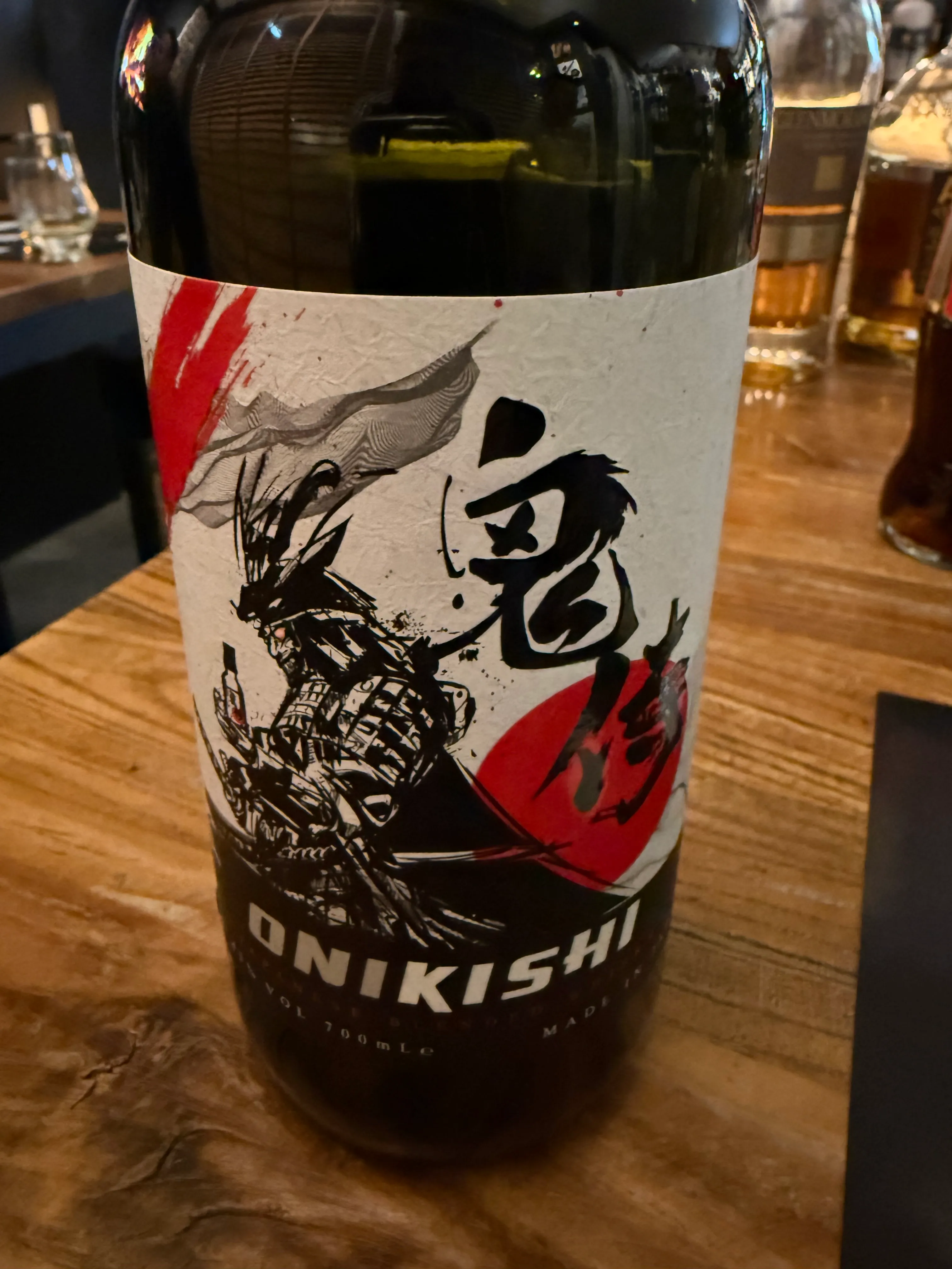 Bottle with Japanese label on wooden table.