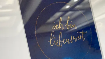 Karte mit handgeschriebenem Text im Rahmen.