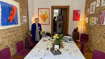 Frau steht in einem bunten Kunststudio.
