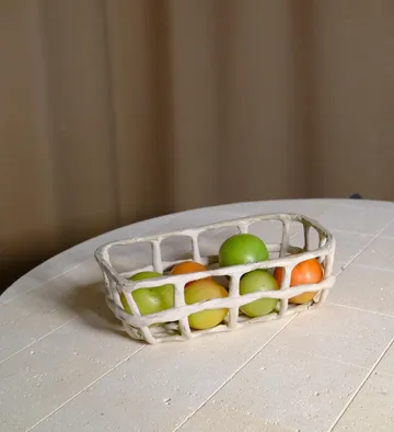 Fruit basket on round table.