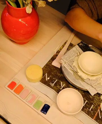Ceramic painting setup on wooden table.