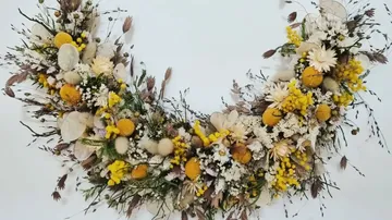 Blumenkranz mit weißen und gelben Blumen.