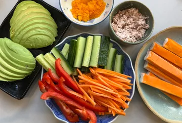 Ingredients for sushi rolls on plates and bowls.